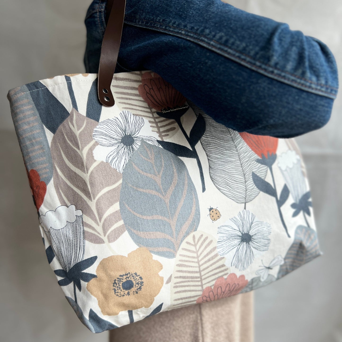 Modelled view of blush flowery tote bag with real leather handles. Handmade by Tallulah Riley