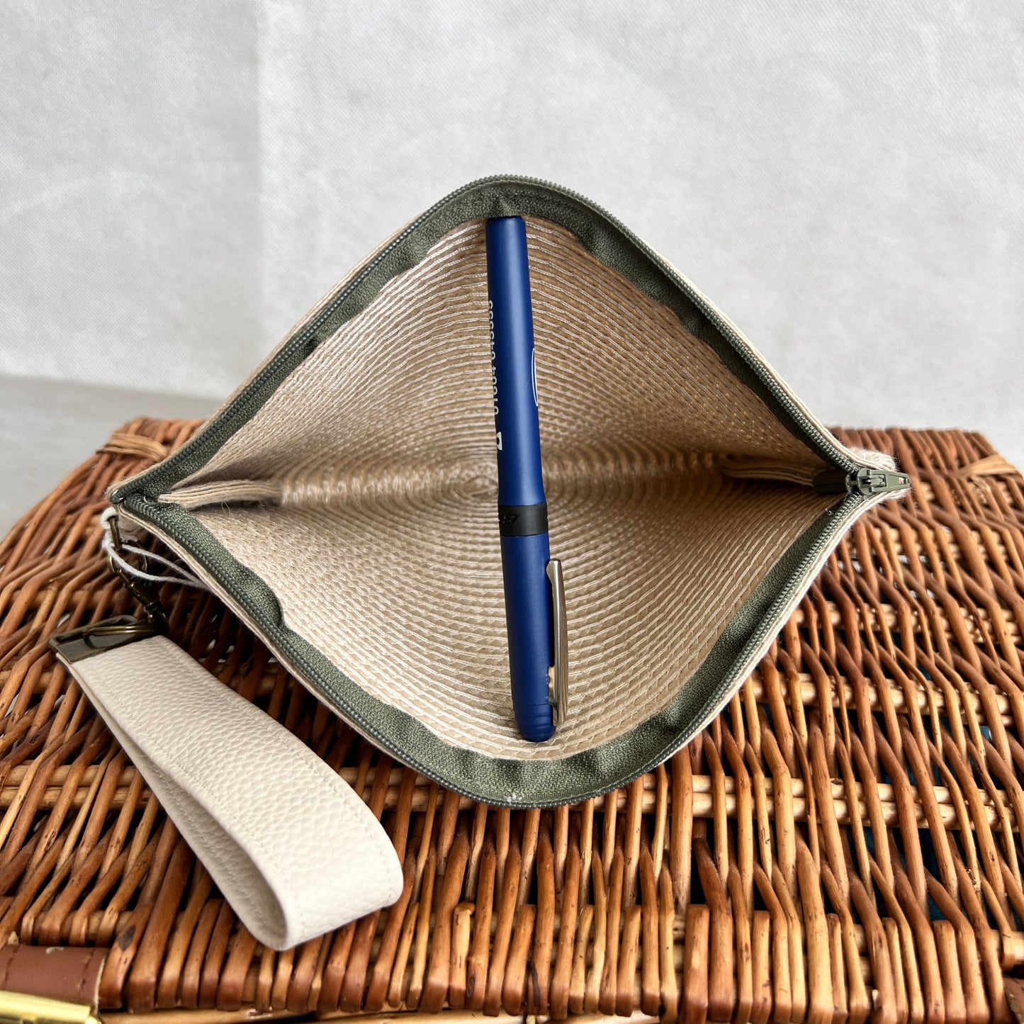 inside view cream woven clutch bag with khaki green zip and cream faux leather detachable wristlet, handmade by Tallulah Riley