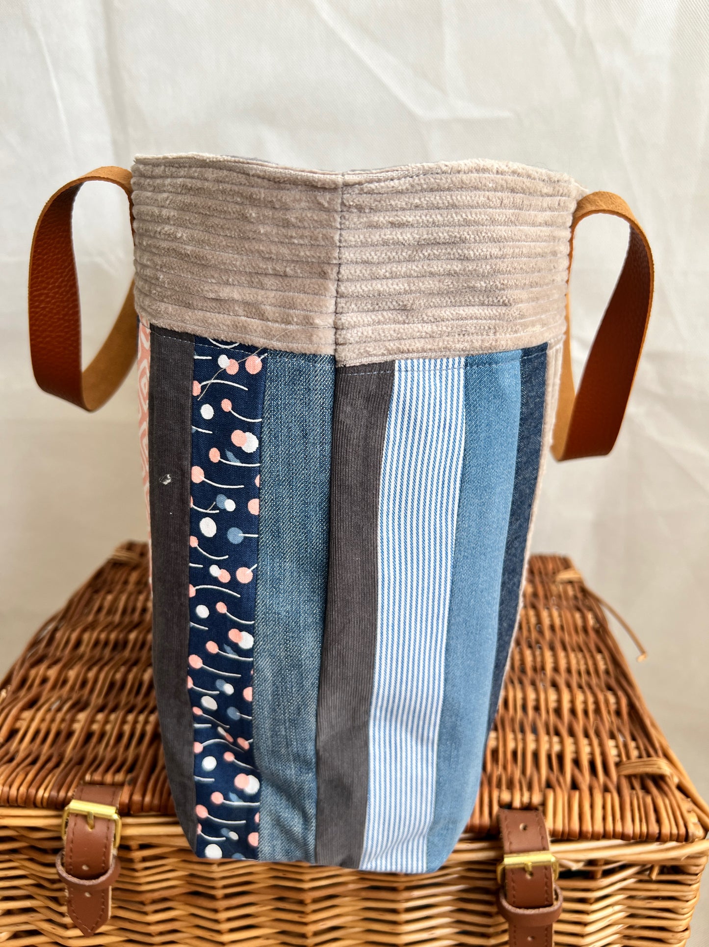 Side view of upcycled tote bag made from denim, corduroy and cotton fabric scraps with leather handles, handmade by Tallulah Riley