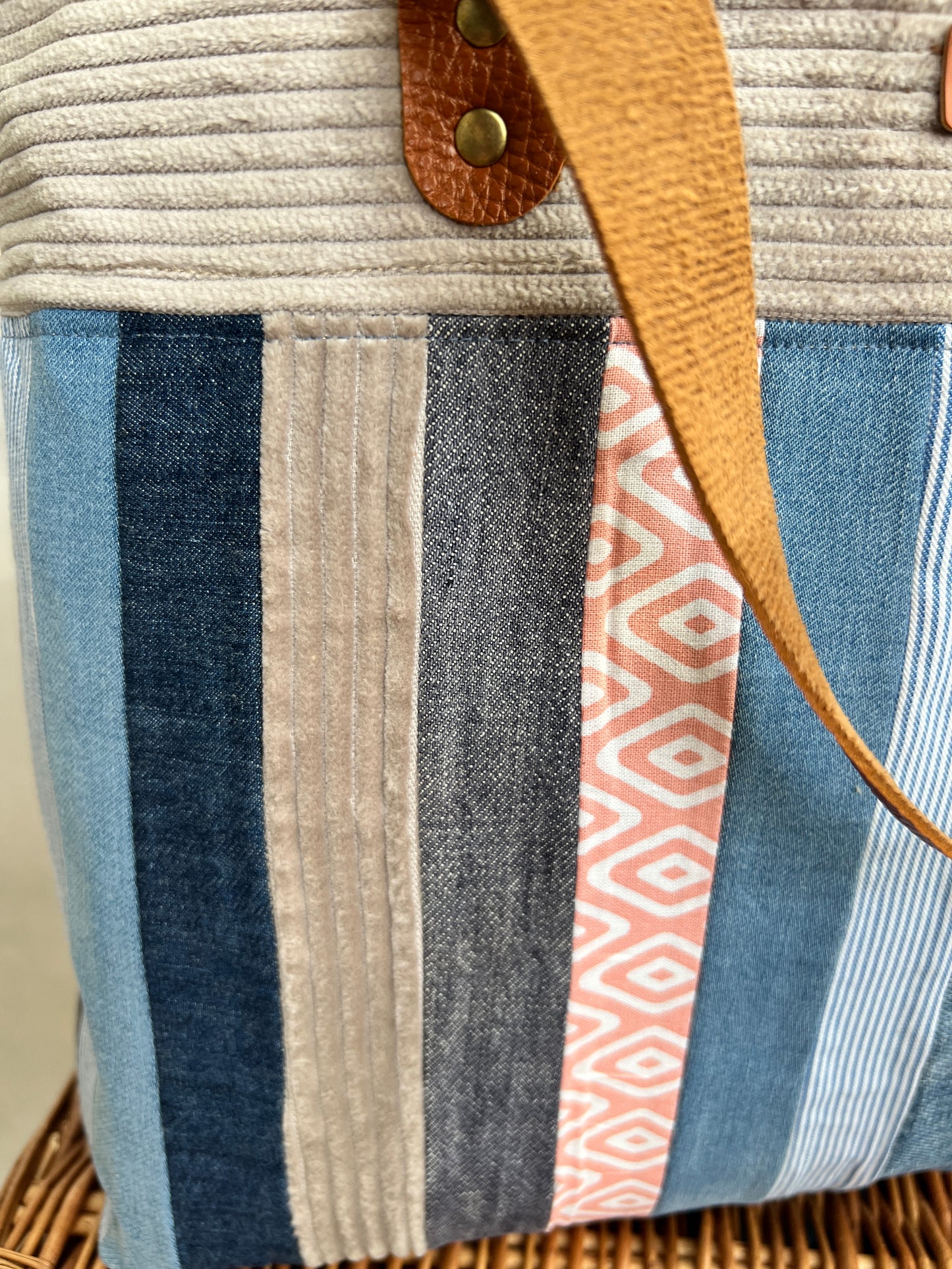 Close up view of upcycled tote bag made from denim, corduroy and cotton fabric scraps with leather handles, handmade by Tallulah Riley
