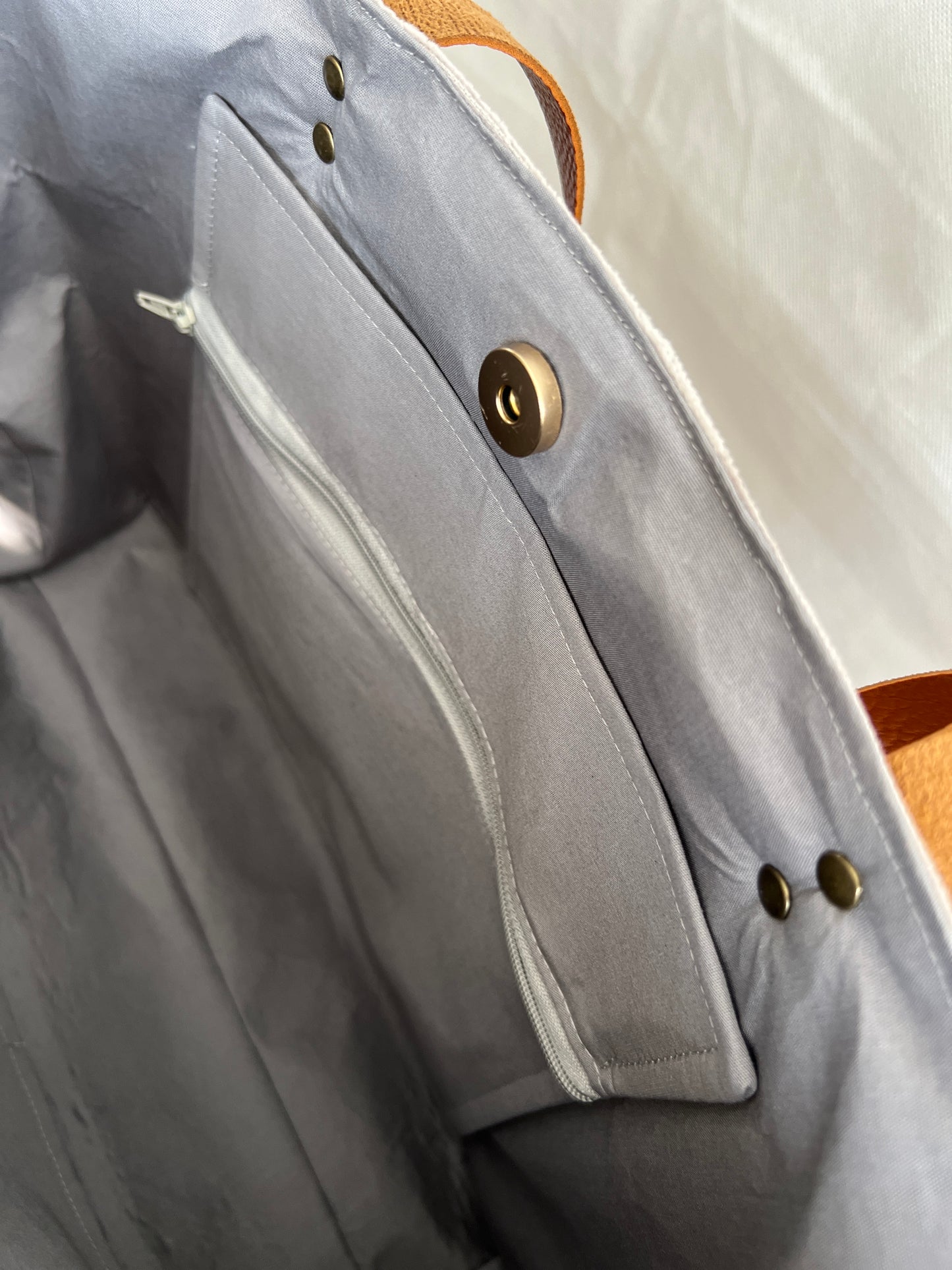 Inside view of upcycled tote bag made from denim, corduroy and cotton fabric scraps with leather handles, 3 inside pockets, on zipped, handmade by Tallulah Riley