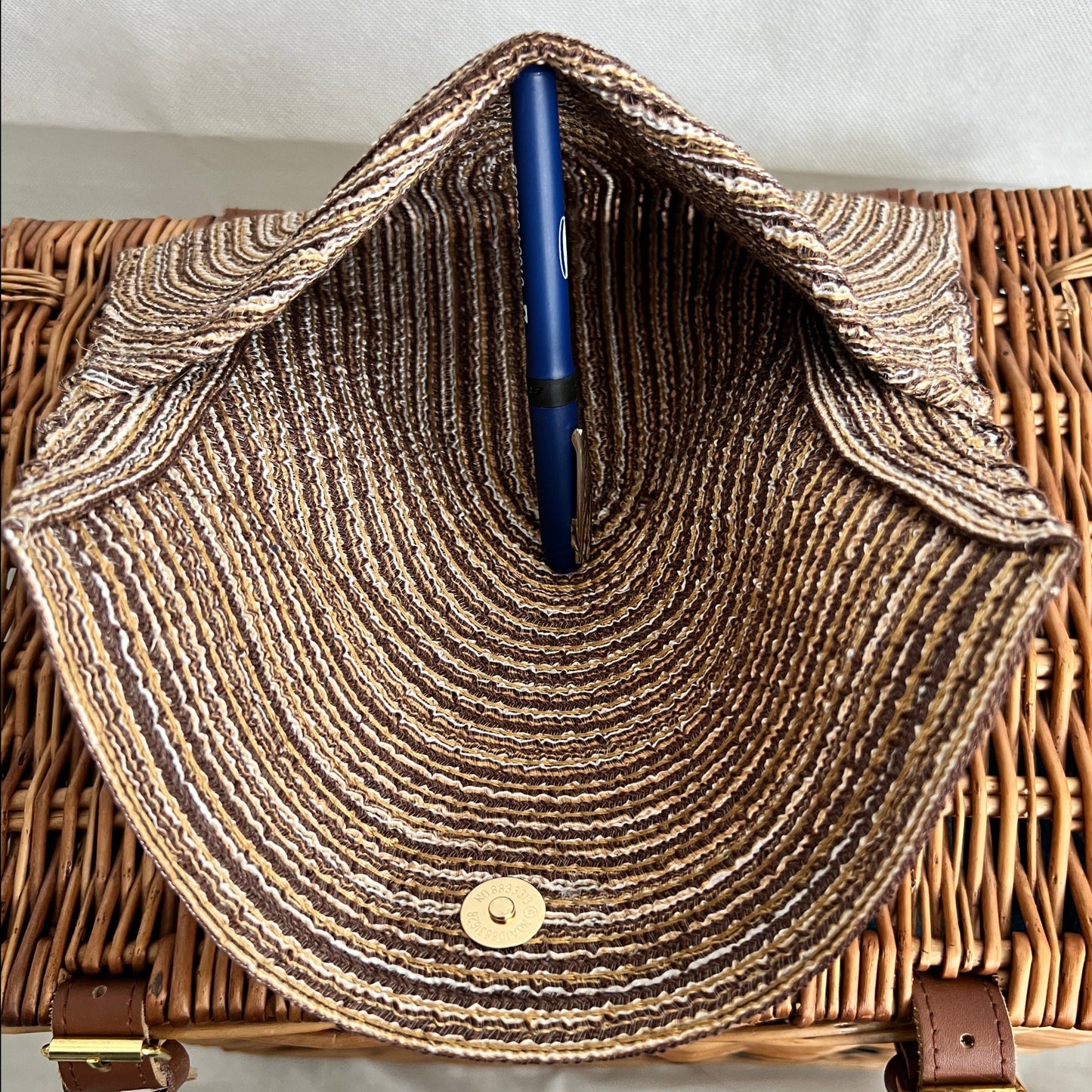 inside view of neutral woven clutch bag with gold magnetic fastening, handmade by Tallulah Riley
