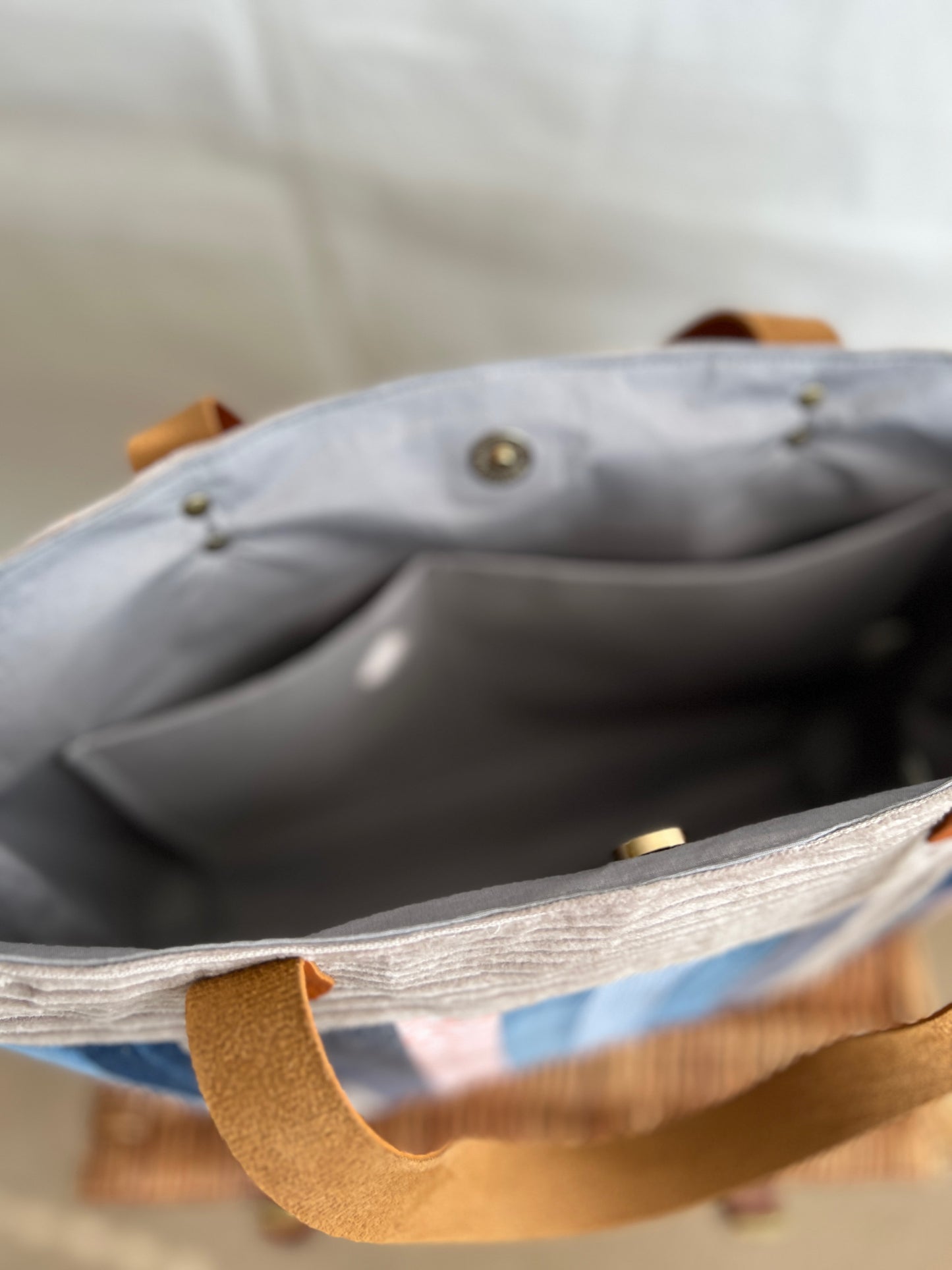 Inside view of upcycled tote bag made from denim, corduroy and cotton fabric scraps with leather handles, 3 inside pockets, on zipped, handmade by Tallulah Riley