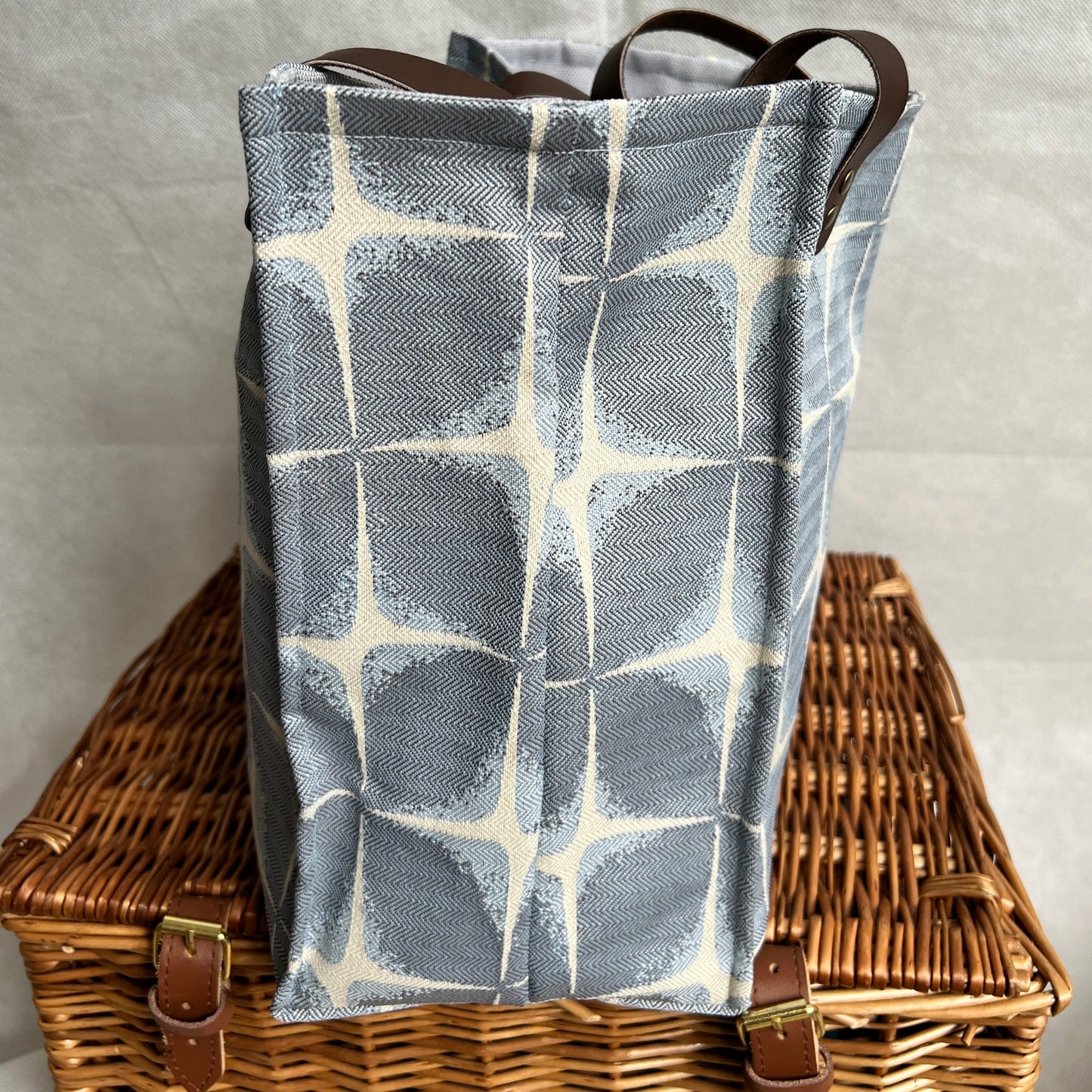 side view of blue and cream boxy tote bag with brown leather handles, handmade by Tallulah Riley