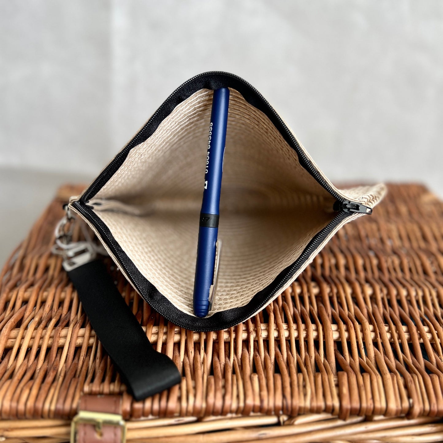 inside view of cream woven clutch bag with black zip and black detachable wristlet, handmade by Tallulah Riley