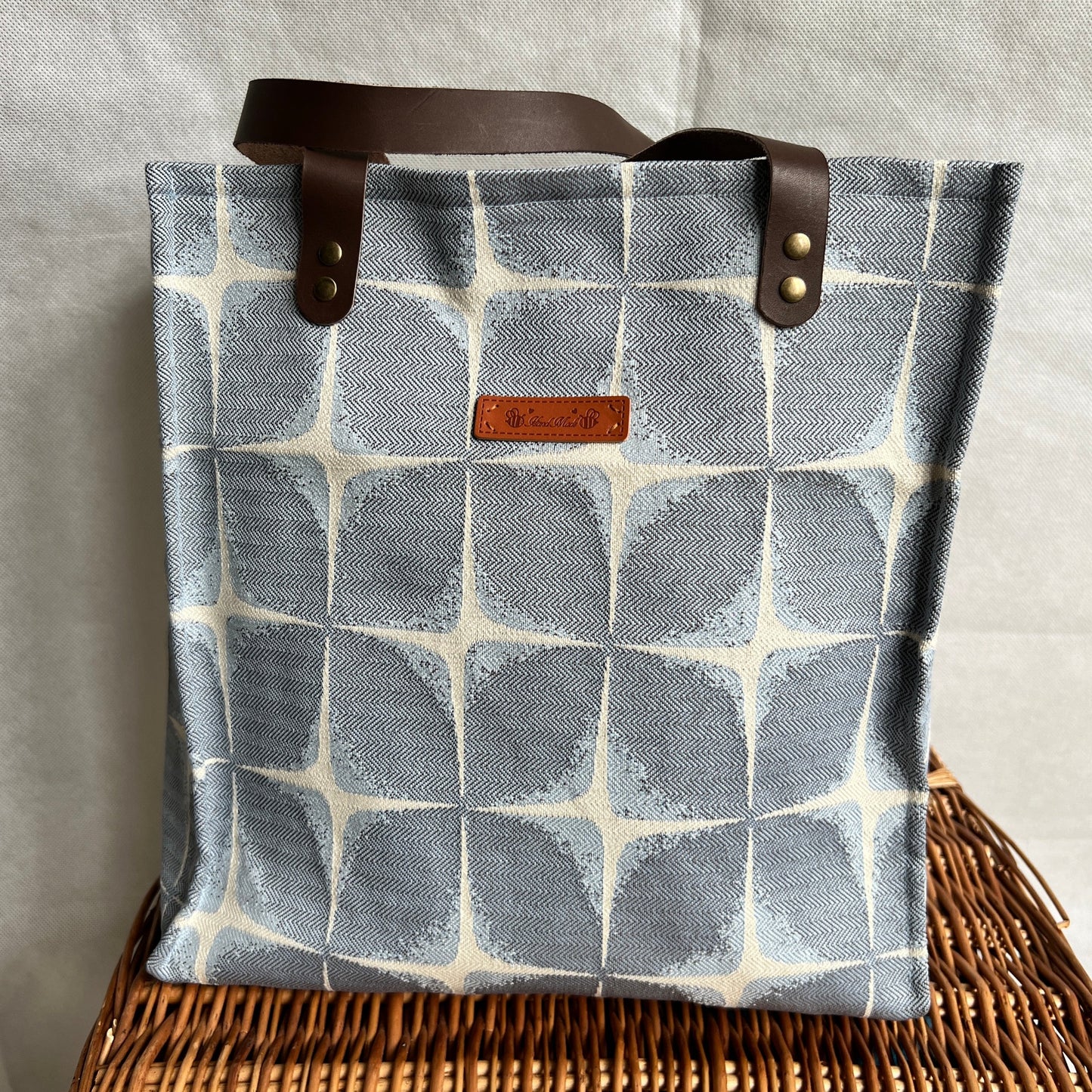 front view of blue and cream boxy tote bag with brown leather handles, handmade by Tallulah Riley