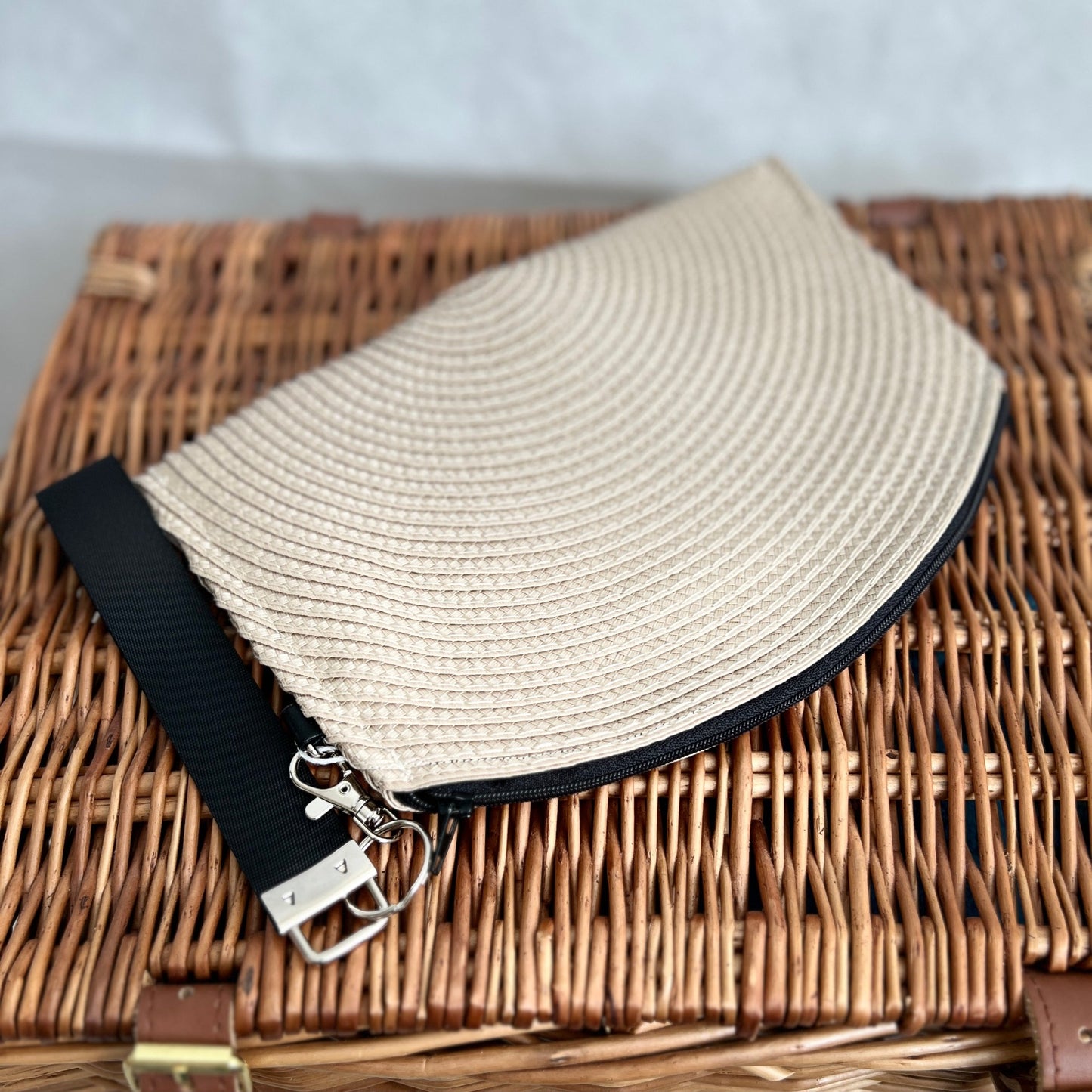 front view of cream woven clutch bag with black zip and black detachable wristlet, handmade by Tallulah Riley
