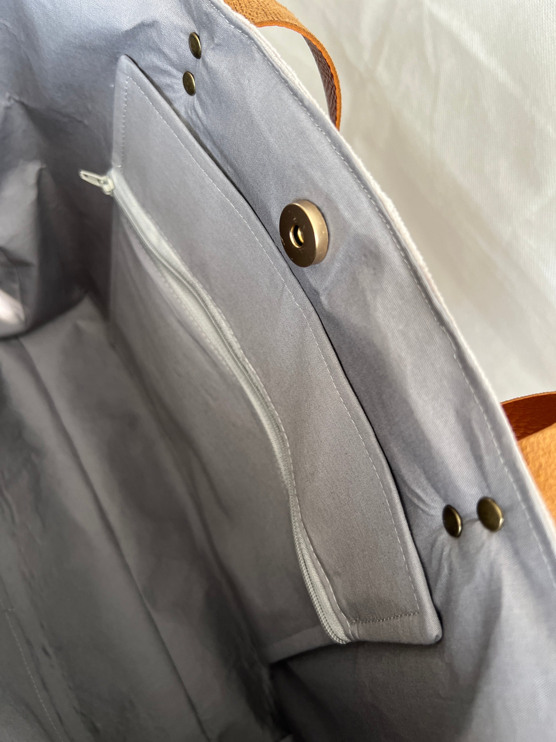 Inside view of upcycled tote bag made from denim, corduroy and cotton fabric scraps with leather handles, 3 inside pockets, on zipped, handmade by Tallulah Riley