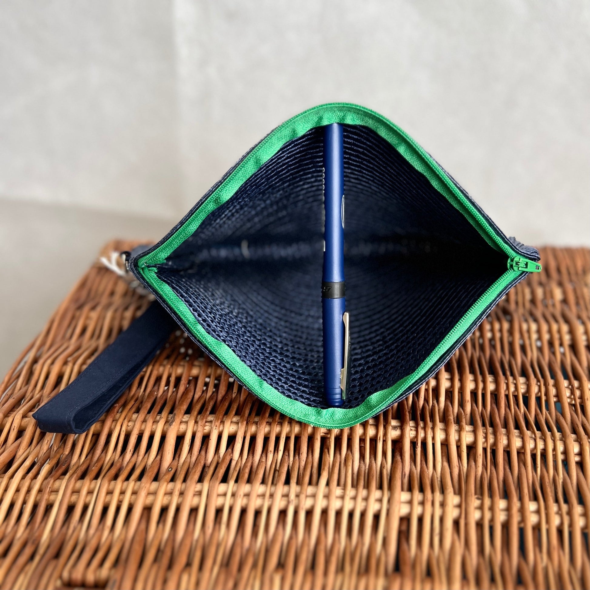 inside view of navy blue woven clutch bag with green zip and detachable navy blue wristlet, handmade by Tallulah Riley