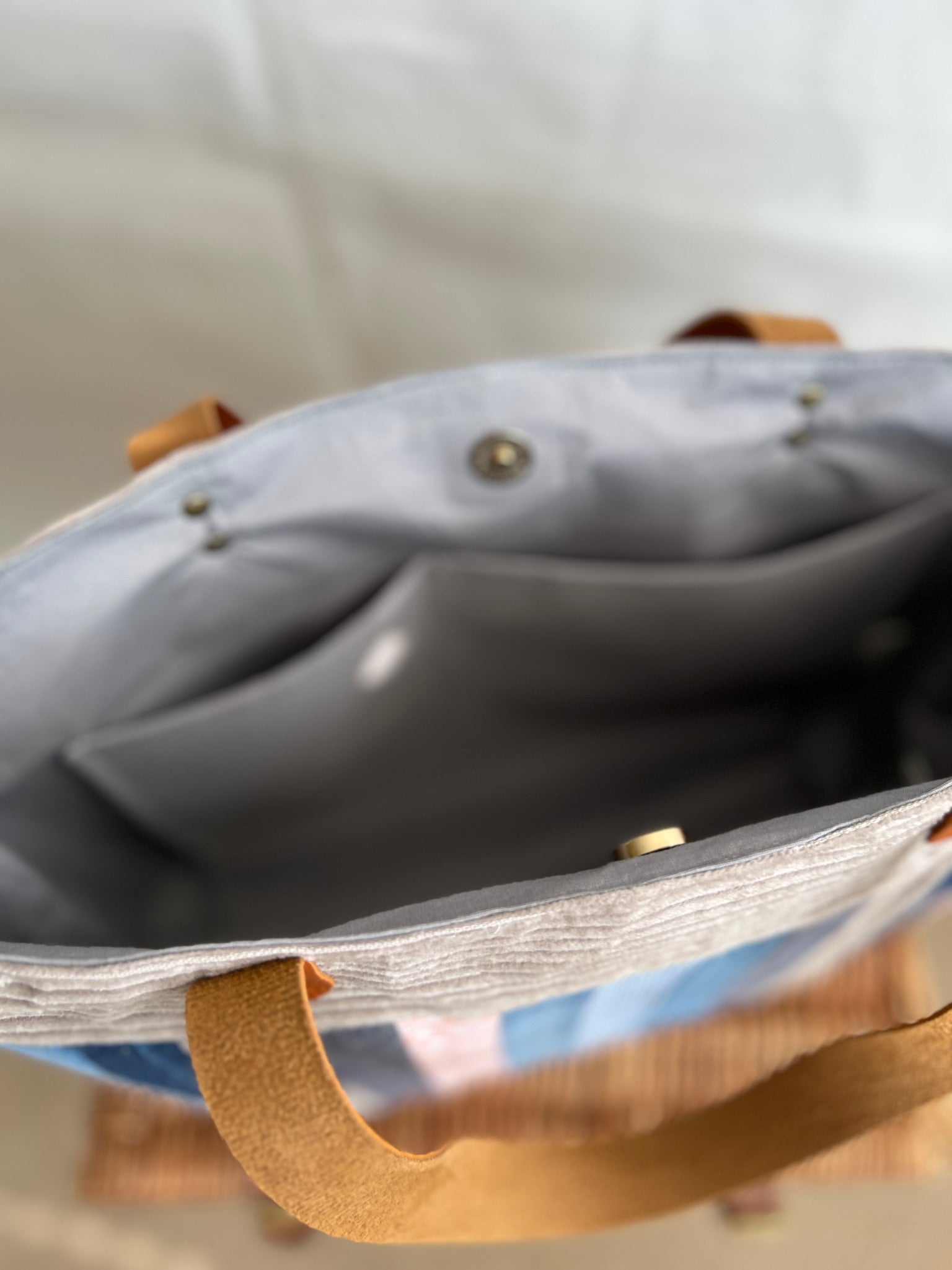 Inside view of upcycled tote bag made from denim, corduroy and cotton fabric scraps with leather handles, 3 inside pockets, on zipped, handmade by Tallulah Riley