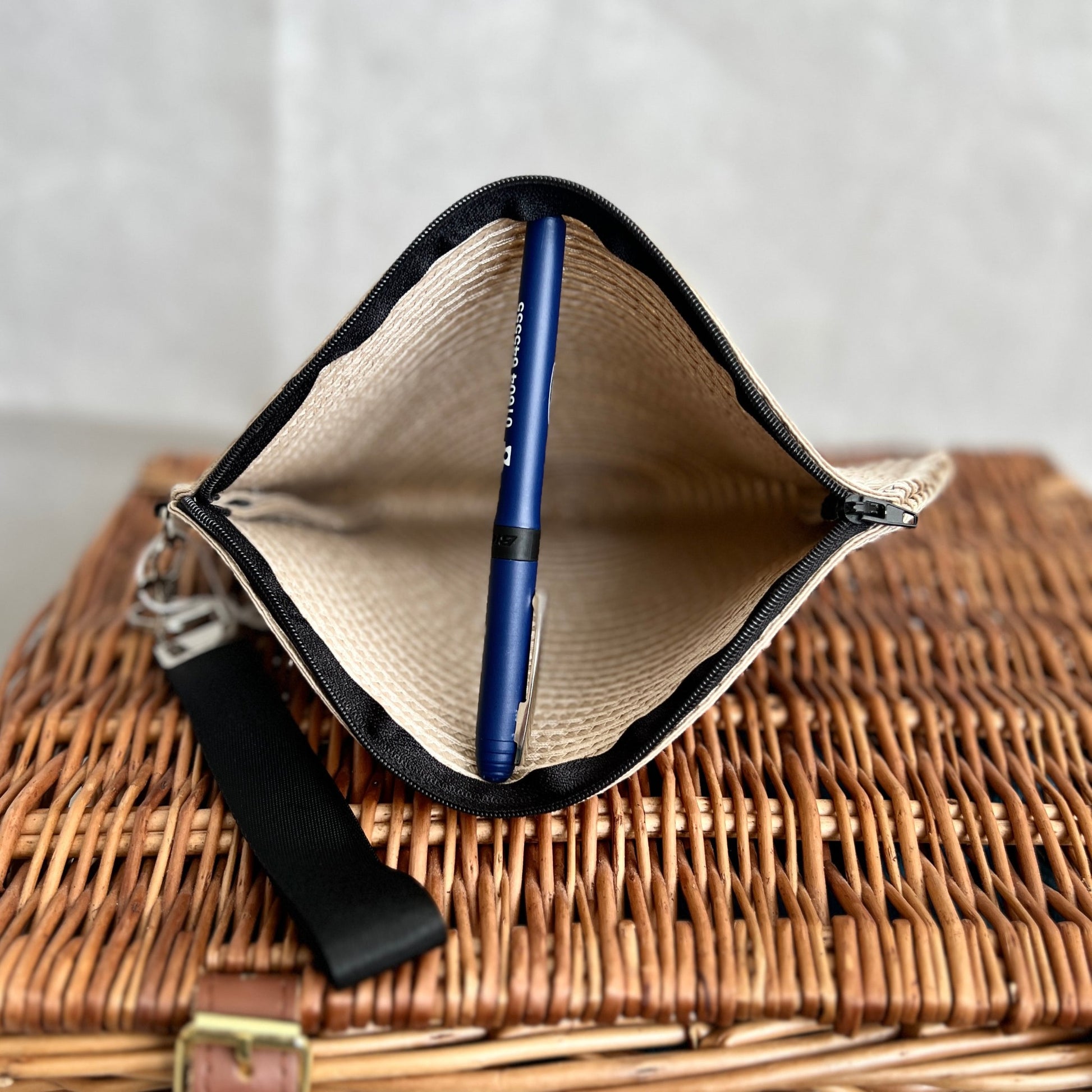 inside view of cream woven clutch bag with black zip and black detachable wristlet, handmade by Tallulah Riley