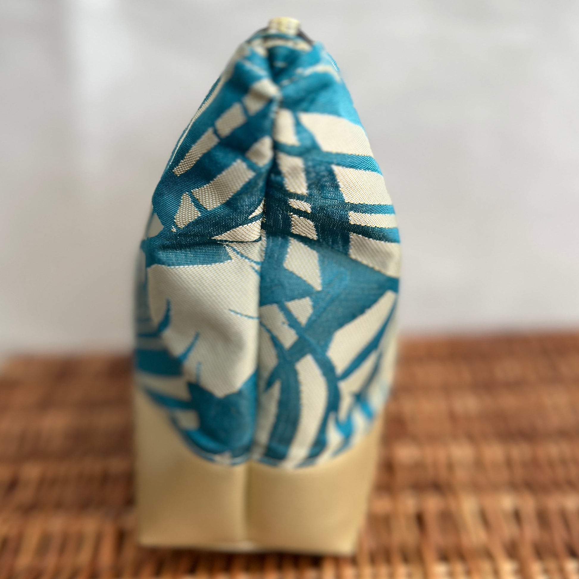 side view of luxurious faux gold leather and teal and gold fabric accessories, make-up bag pouch with gold zip, handmade by Tallulah Riley