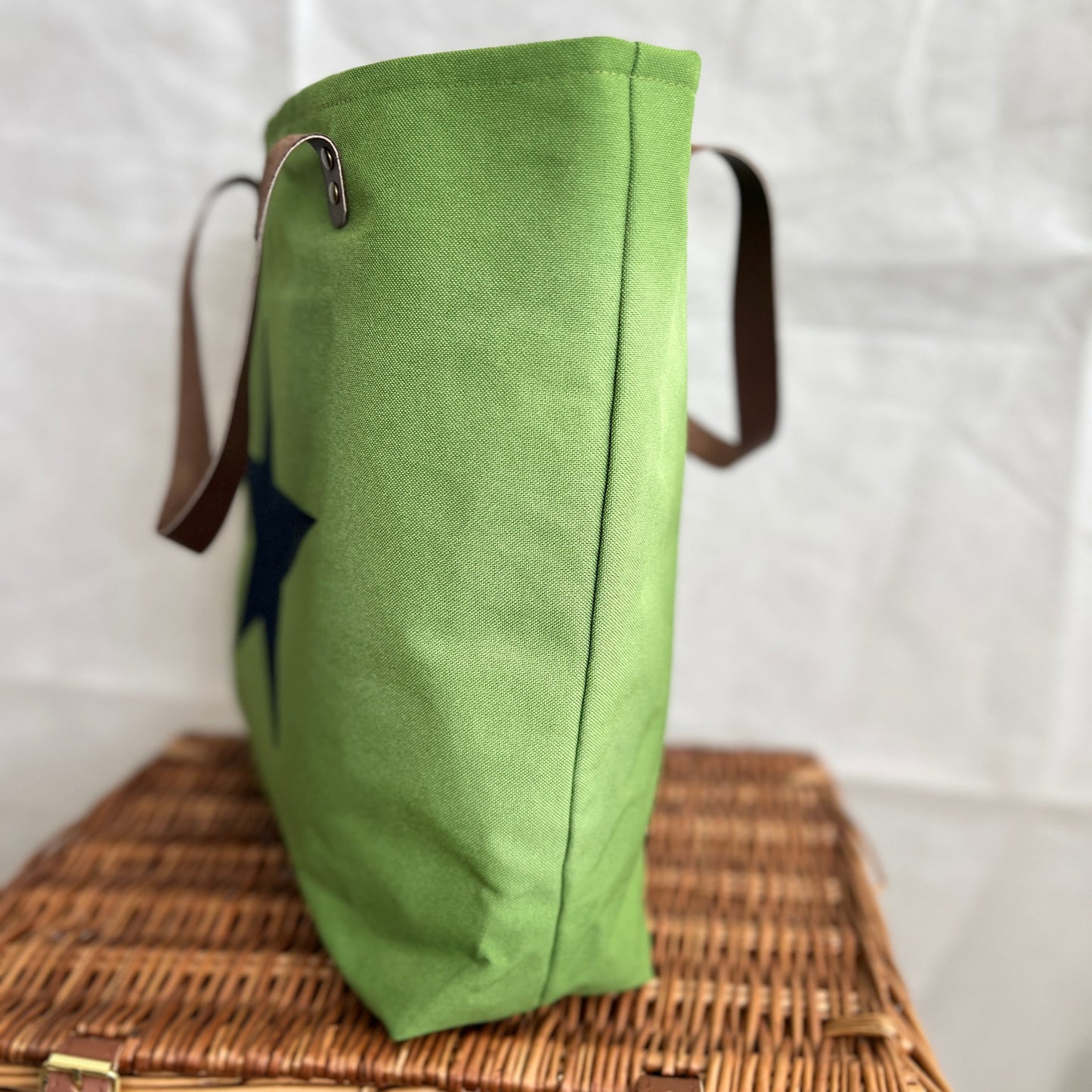 side view of bright green tote bag, brown leather handles, handmade by Tallulah Riley